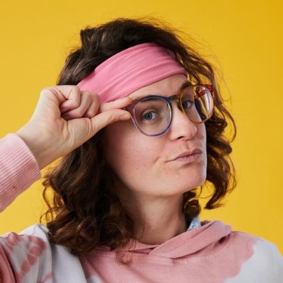 Liz Wilcox with glasses and a pink headband